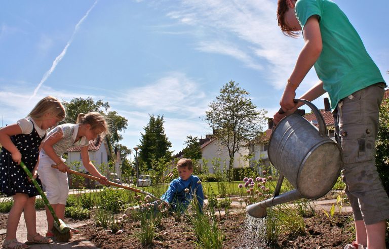 Kinderen geven planten water in hun buurt